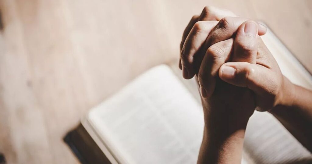 A man stands in a field of yellow flowers, arms outstretched, embodying the essence of Best Sunday Morning Prayer Messages.