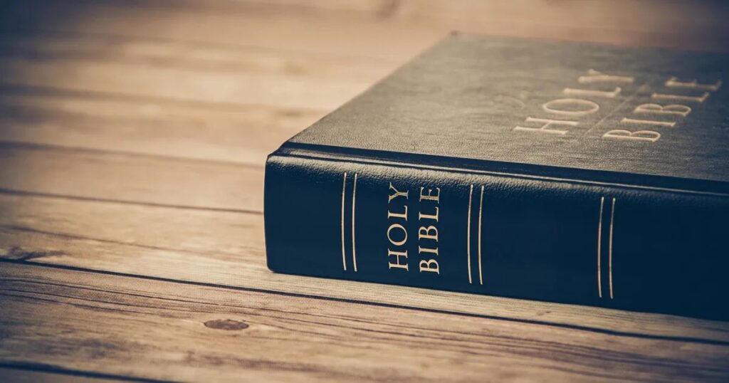 A Bible resting on a wooden table, symbolizing the reflection on Short Sunday Bible Verses.