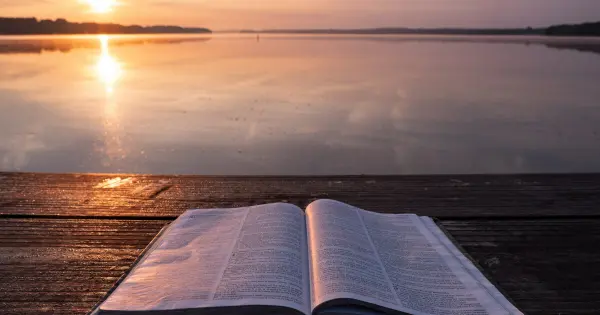 Bible resting on a dock at sunset, embodying the essence of Wednesday Words of Wisdom in a serene setting.