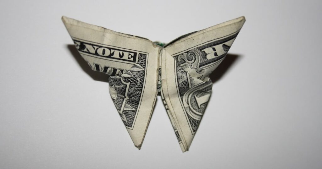 A folded dollar bill shaped like a butterfly, representing the question: What does the Butterfly symbolize?
