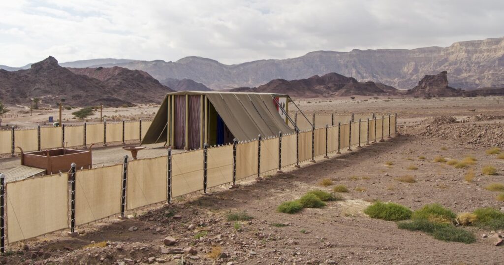 A tent surrounded by a fence in the desert, symbolizing "The Number 5 and God's Tabernacle" in a serene landscape.